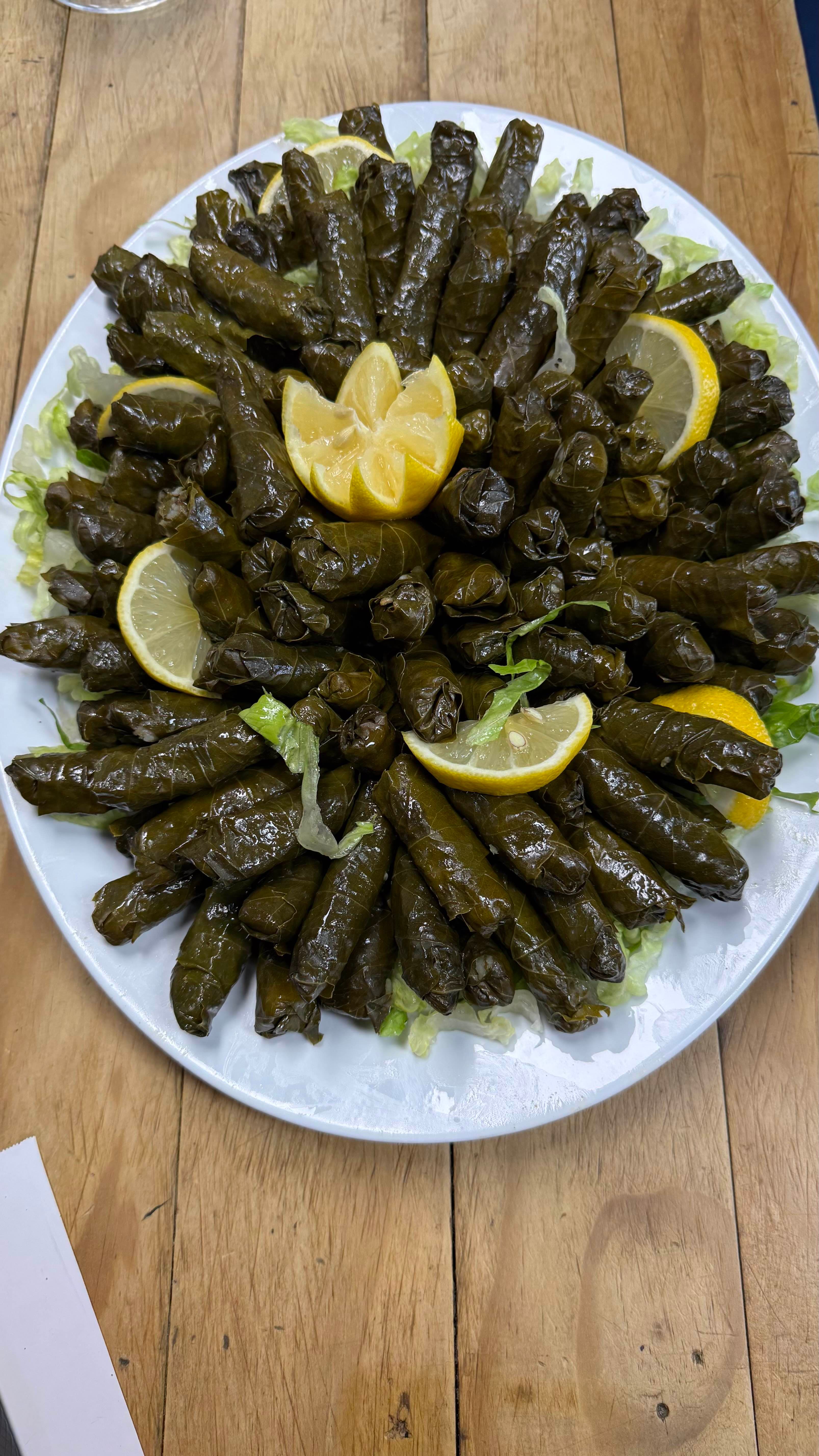 Hand-rolled stuffed grape leaves with lemon wedges