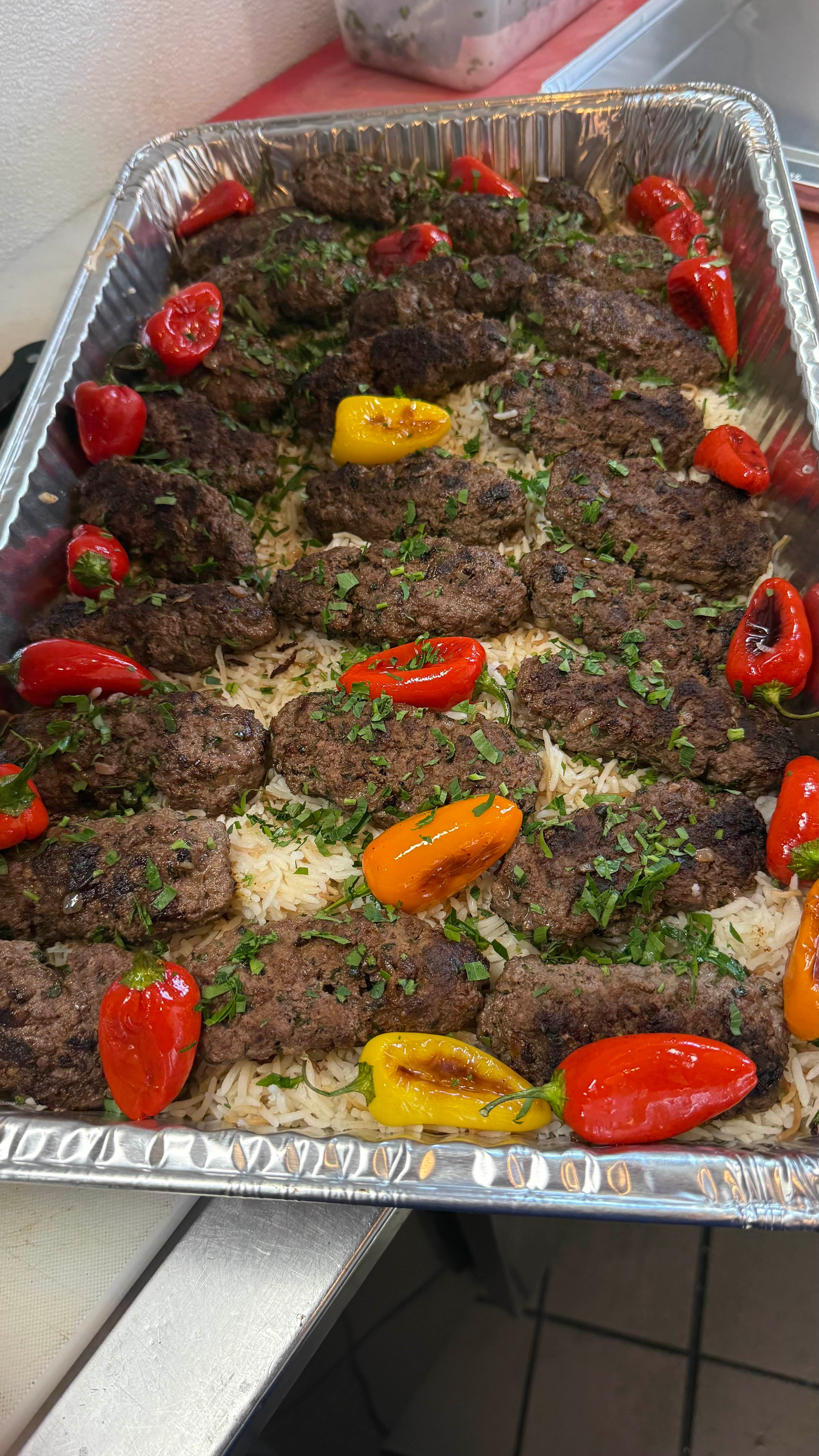 Grilled kafta kebab on rice with roasted peppers
